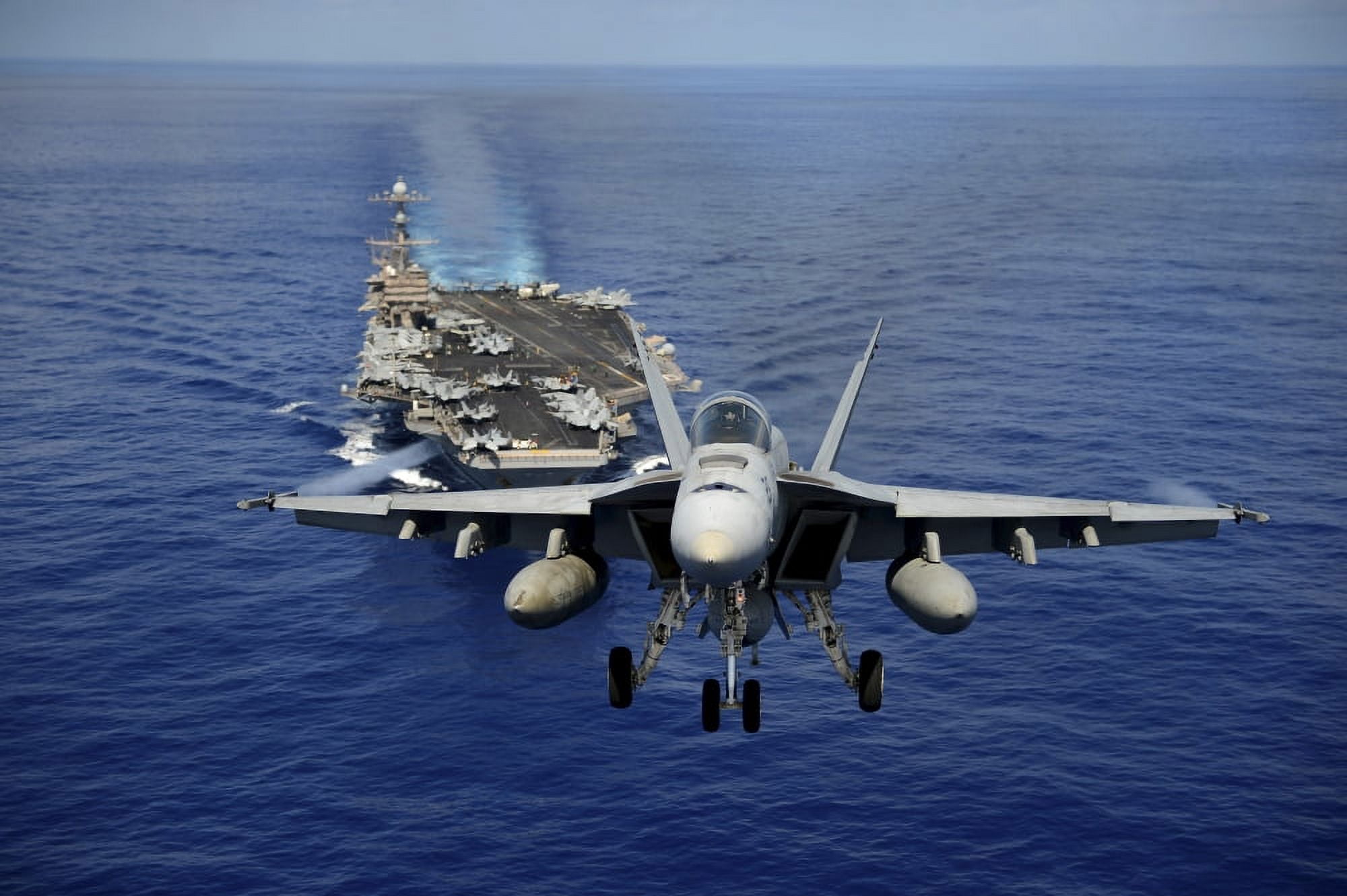 An FA-18E Super Hornet flying above USS John C Stennis Canvas Art - Stocktrek Images (35 x 23)