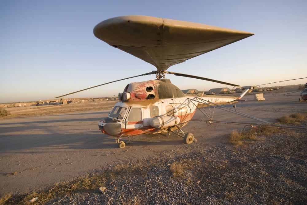 An Iraqi helicopter sits on the flight deck abandoned at Camp Warhorse Canvas Art - Terry MooreStocktrek Images (18 x 12)