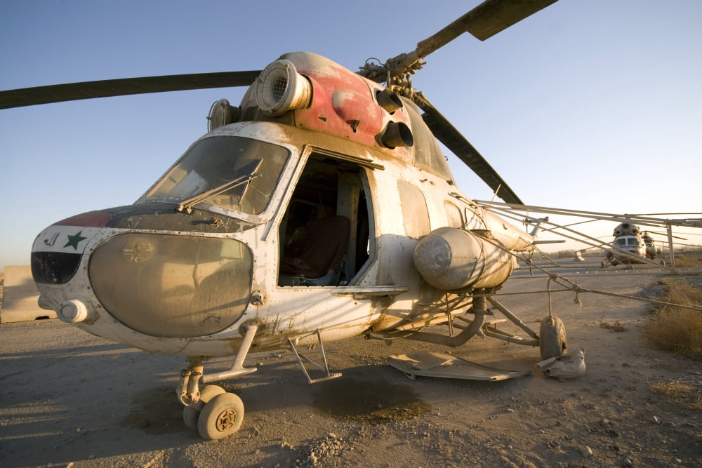 An Iraqi helicopter sits on the flight deck abandoned at Camp Warhorse Canvas Art - Terry MooreStocktrek Images (35 x 23)