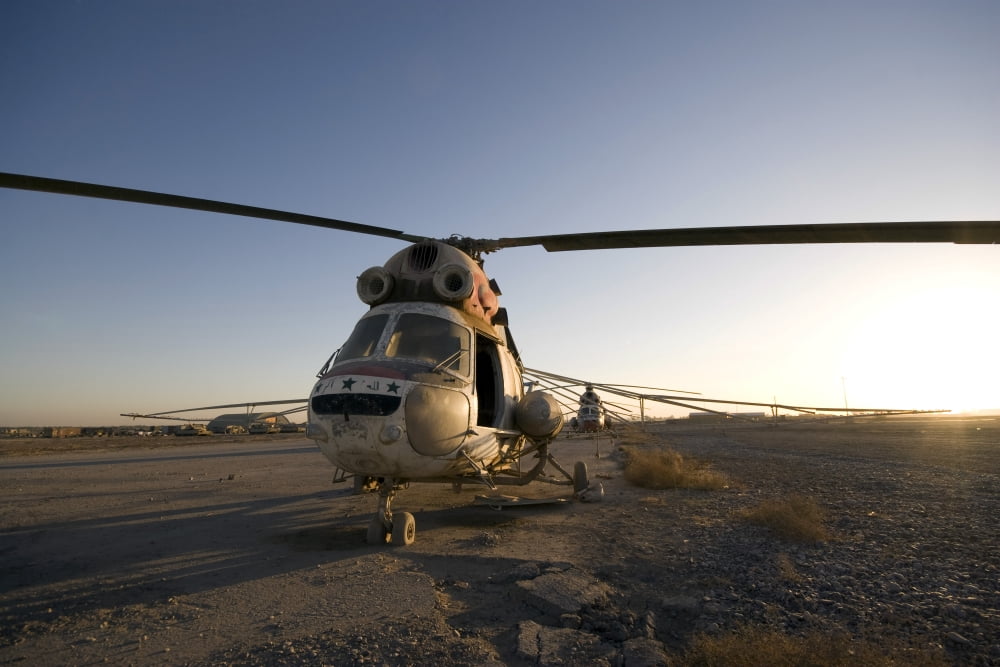 An Iraqi helicopter sits on the flight deck abandoned at Camp Warhorse Canvas Art - Terry MooreStocktrek Images (35 x 23)
