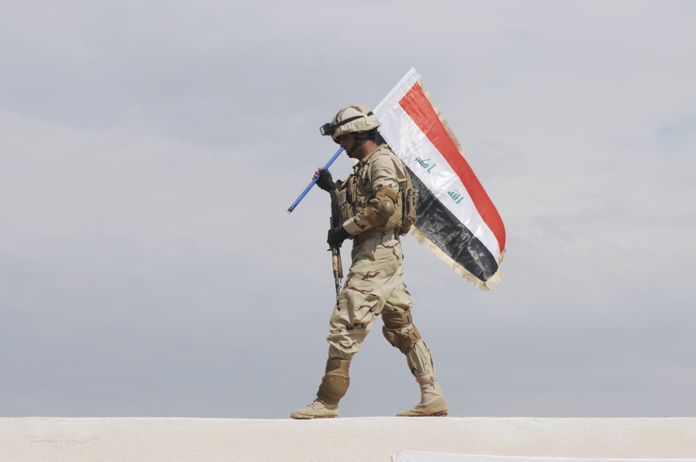 An Iraqi soldier carries the Iraqi flag Canvas Art - Stocktrek Images (34 x 23)