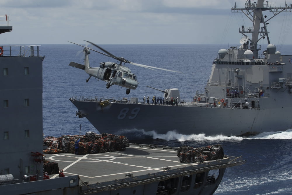 An MH-60S Knighthawk helicopter transports a pallet of supplies to USS Essex Canvas Art - Stocktrek Images (35 x 23)