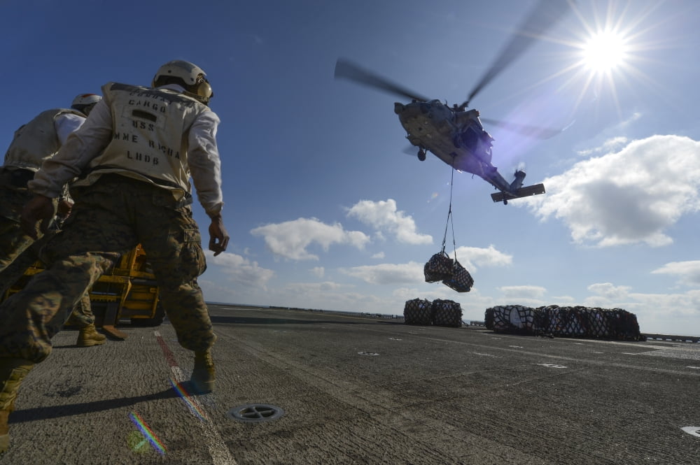 An MH-60S Sea Hawk helicopter lowers pallets of supplies onto USS Bonhomme Richard Canvas Art - Stocktrek Images (35 x 23)