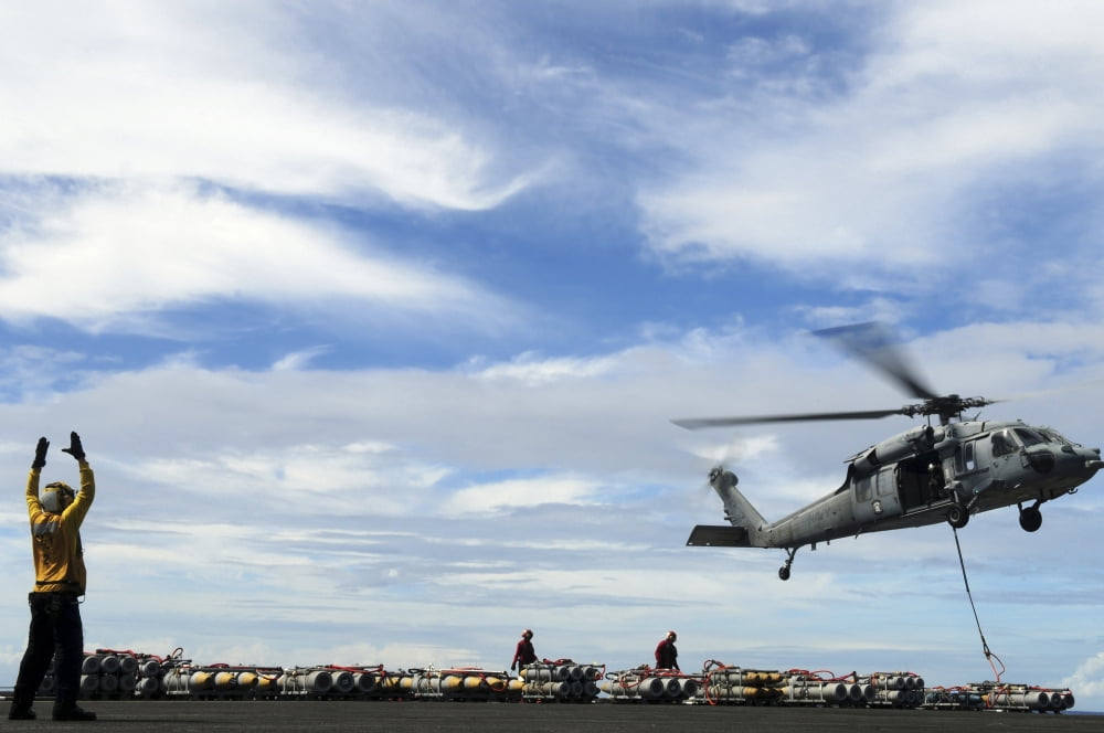 An MH-60S Sea Hawk lifts a pallet of ordnance from the aircraft carrier USS Ronald Reagan Canvas Art - Stocktrek Images (34 x 23)