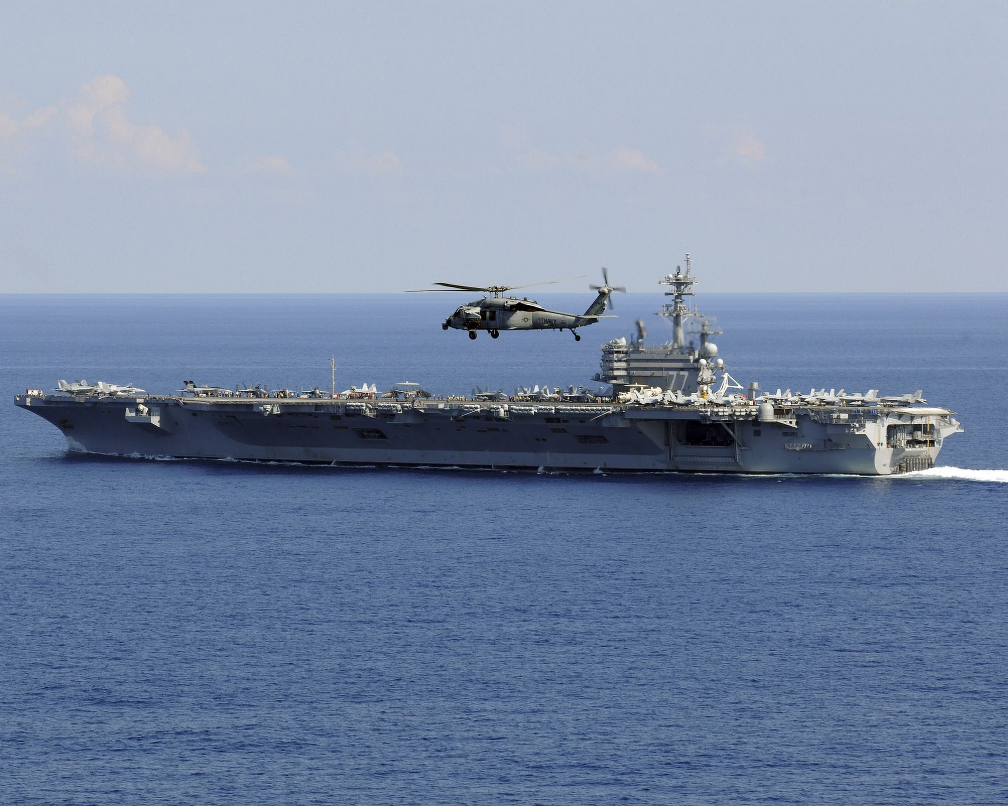 An MH-60S Seahawk helicopter flies over USS George HW Bush Canvas Art - Stocktrek Images (32 x 25)