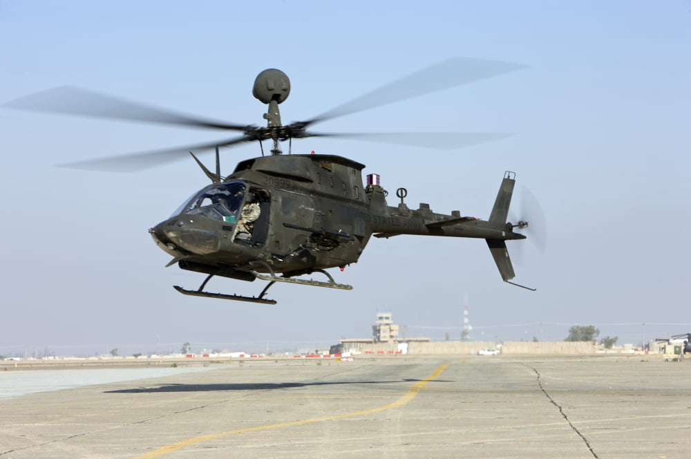 An OH-58D Kiowa Warrior hovers over the flight line at Camp Speicher Iraq Canvas Art - Terry MooreStocktrek Images (35 x 23)