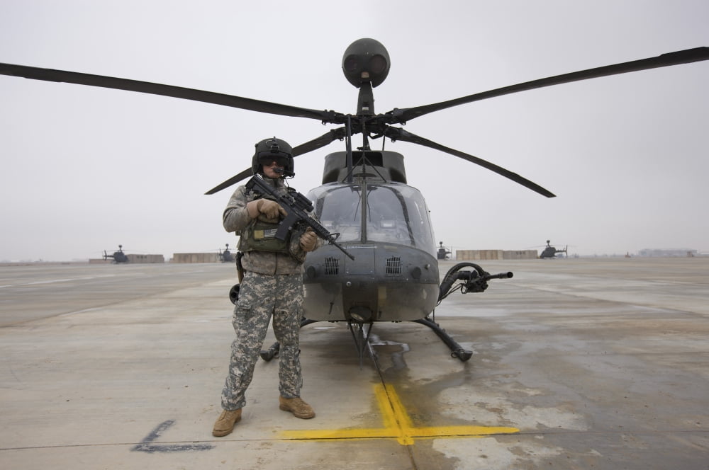 An OH-58D Kiowa Warrior pilot stands beside his aircraft Canvas Art - Terry MooreStocktrek Images (18 x 12)