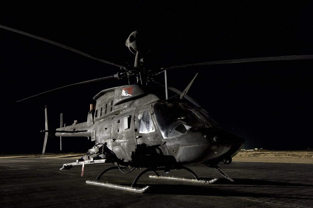 An OH-58D Kiowa sits on its pad at night Canvas Art - Terry MooreStocktrek Images (35 x 23)