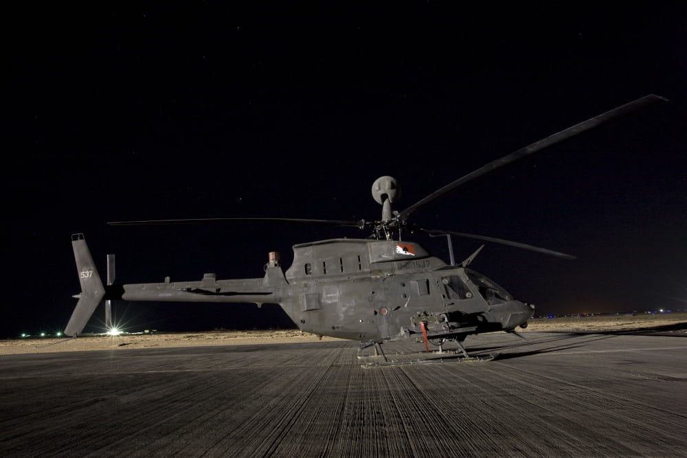 An OH-58D Kiowa sits on its pad at night Canvas Art - Terry MooreStocktrek Images (35 x 23)
