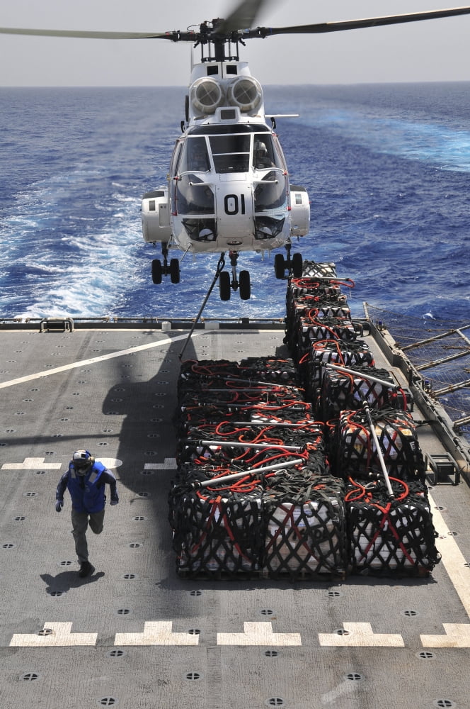 An SA-330J Puma helicopter picking up pallets of supplies from USNS Alan Shepard Canvas Art - Stocktrek Images (23 x 35)