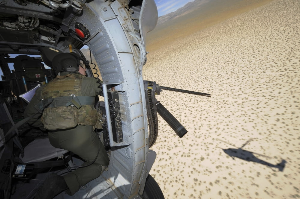 An aerial gunner scans terrain for training targets from an HH-60 Pave Hawk Canvas Art - Stocktrek Images (34 x 23)