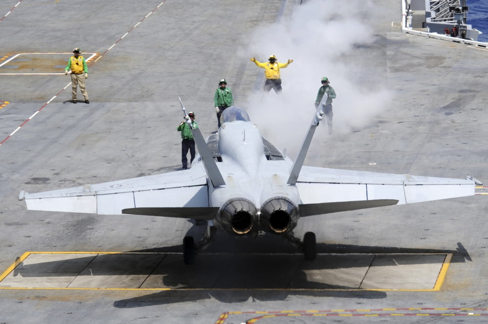 An aircraft director guides an FA-18 Hornet to the catapult aboard the aircraft carrier USS Carl Vinson Canvas Art - Stocktrek Images (34 x 23)