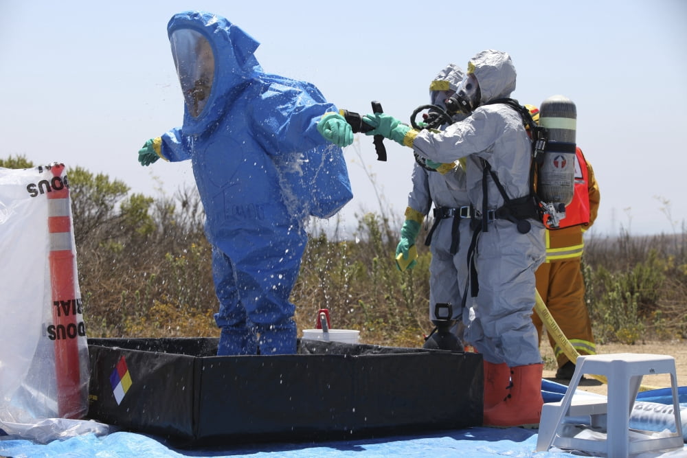 An airman stands in a tub of cleaning solution during a decontamination process Canvas Art - Stocktrek Images (34 x 23)