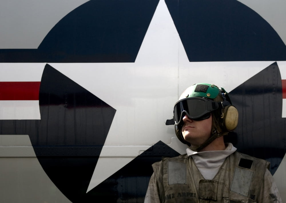 An airman stands in front of a C-2A Greyhound Canvas Art - Stocktrek Images (34 x 24)