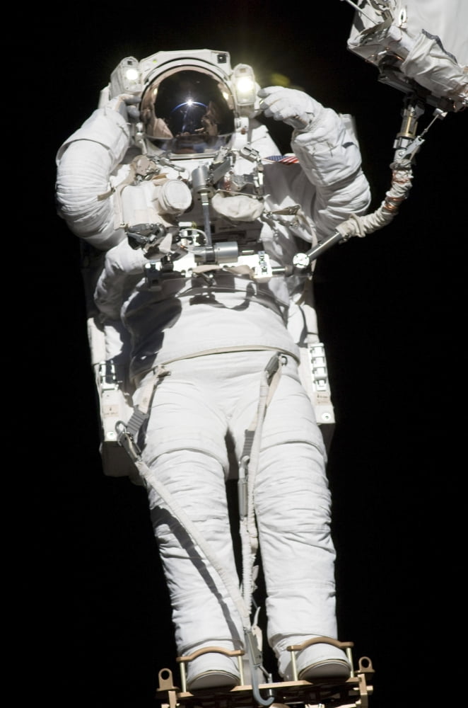 An astronaut anchored to a mobile foot restraint participates in a session of extravehicular activity Canvas Art - Stocktrek Images (23 x 34)