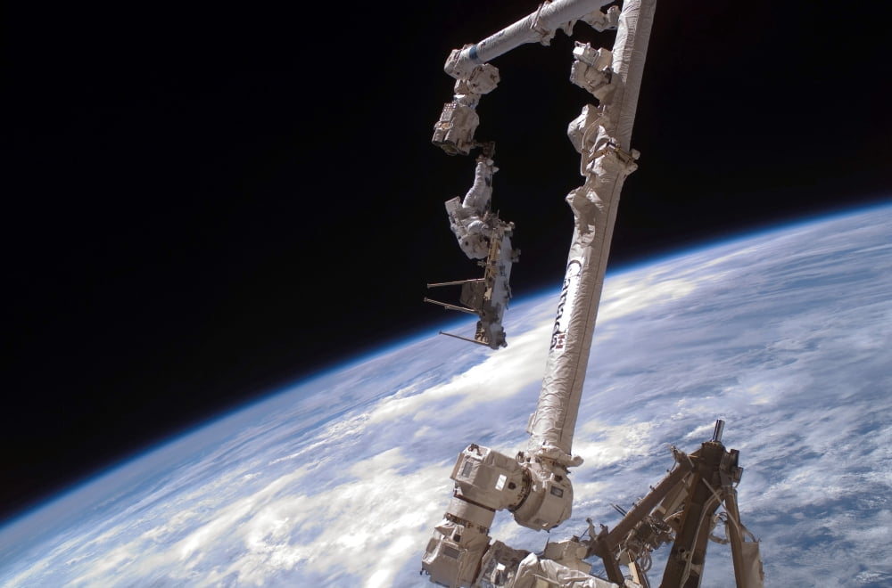 An astronaut anchored to the International Space Stations Canadarm2 foot restraint Canvas Art - Stocktrek Images (34 x 23)