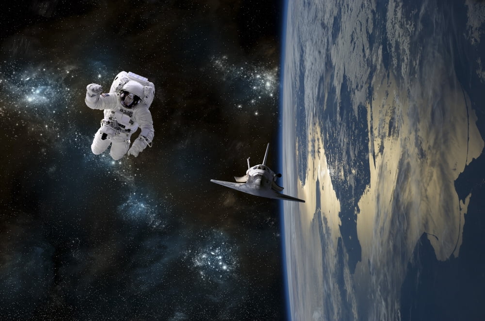 An astronaut drifting in space is rescued by a space shuttle orbiting Earth Canvas Art - Marc WardStocktrek Images (35 x 23)