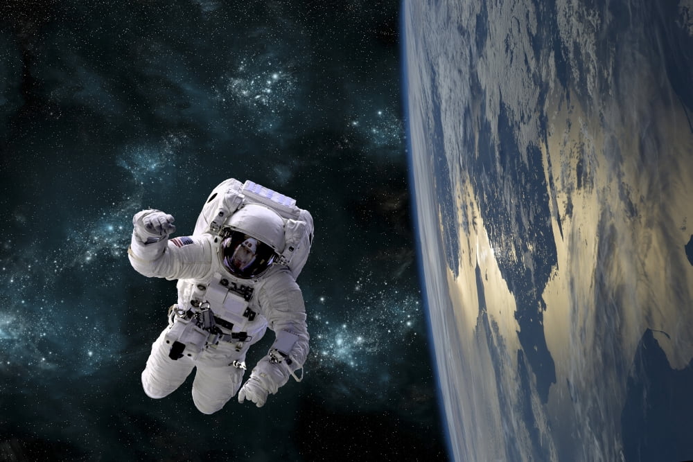 An astronaut floating above Earth Canvas Art - Marc WardStocktrek Images (18 x 12)