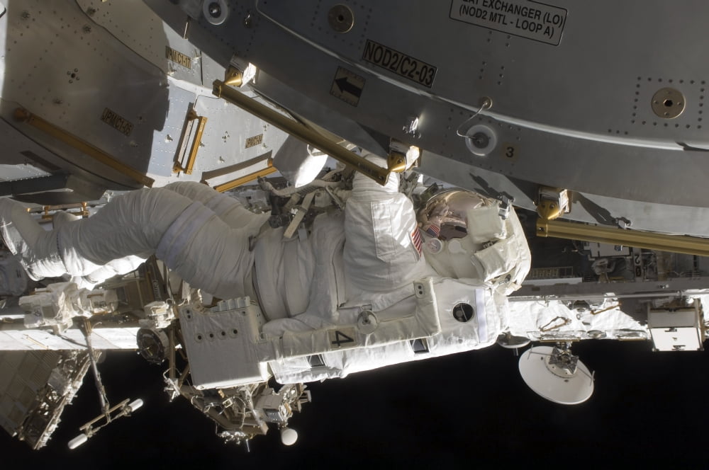 An astronaut holds onto a handrail on Harmony Node 2 during a spacewalk Canvas Art - Stocktrek Images (35 x 23)