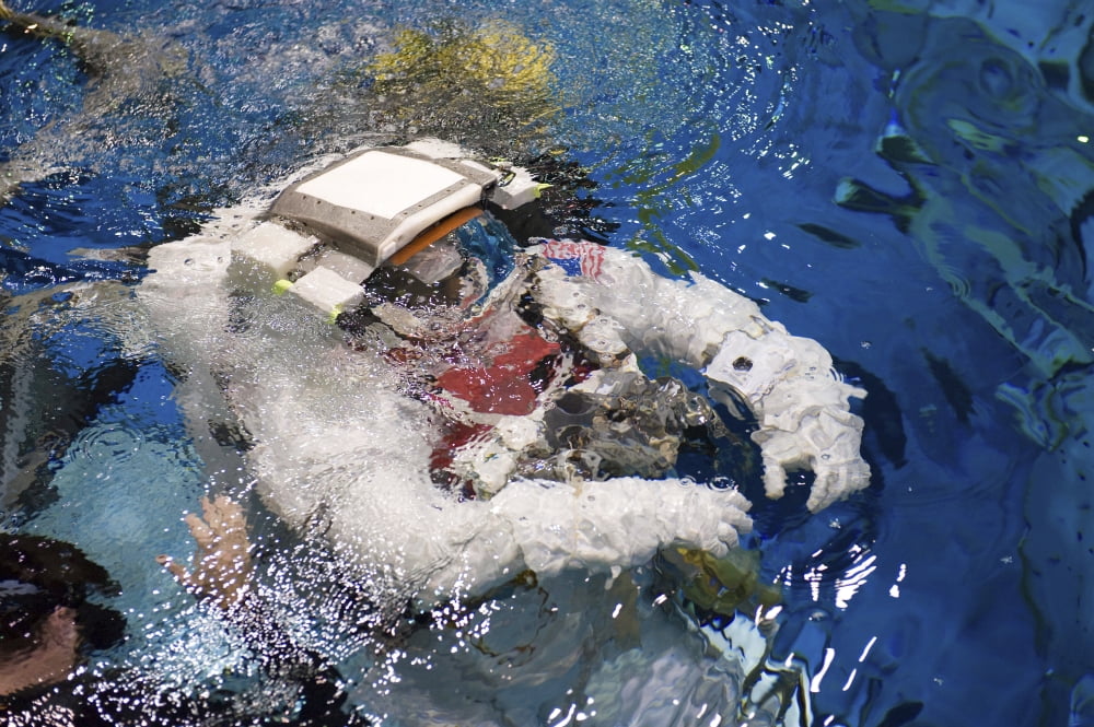 An astronaut is submerged in the water while wearing a Extravehicular Mobility Unit spacesuit Canvas Art - Stocktrek Images (34 x 23)