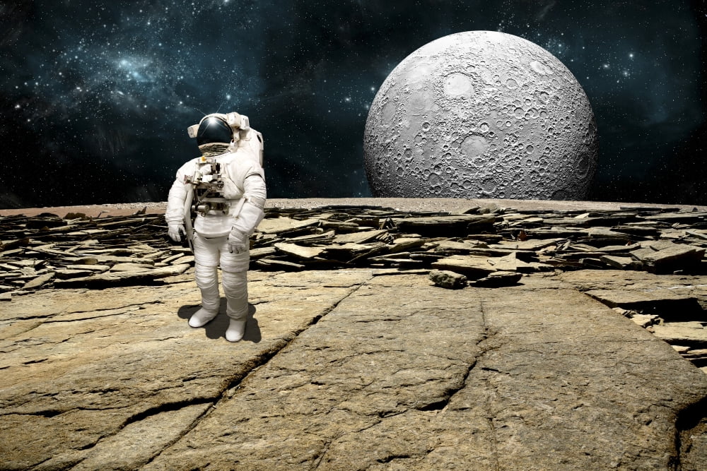 An astronaut on a barren planet with moon rising over the horizon Canvas Art - Marc WardStocktrek Images (35 x 24)