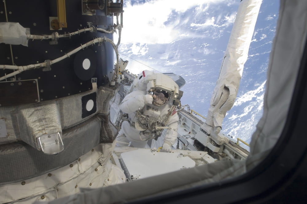 An astronaut participates in the a session of extravehicular activity Canvas Art - Stocktrek Images (34 x 23)