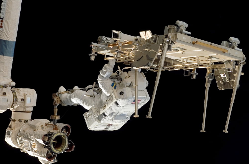 An astronaut with his feet secured on the Canadarm2 Canvas Art - Stocktrek Images (34 x 23)