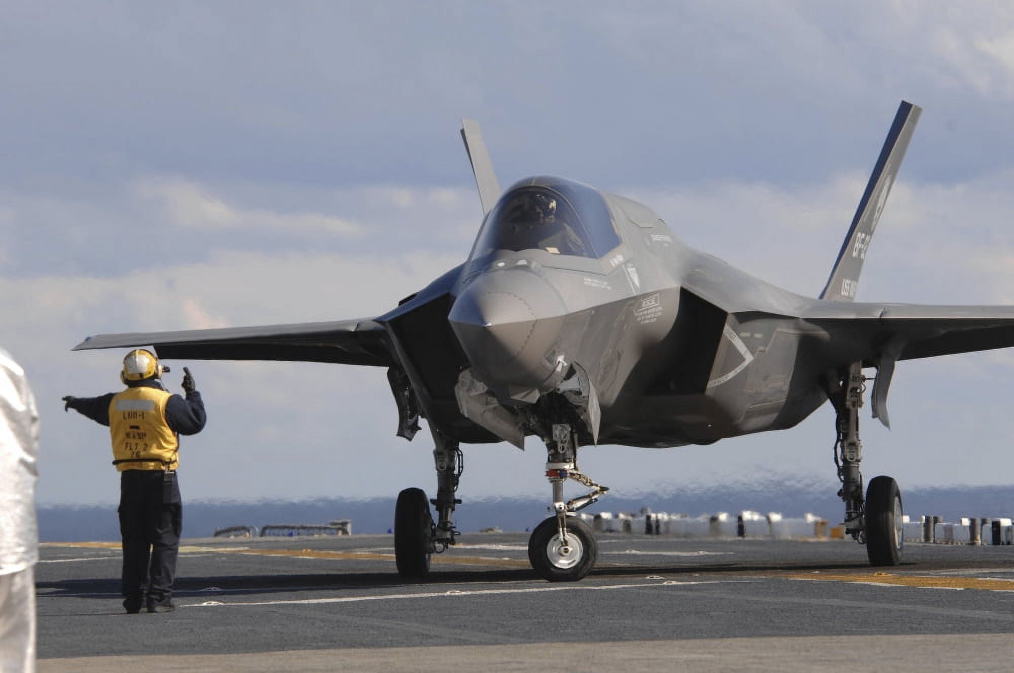An aviation boatswains mate directs an F-35B Lightning II aboard USS Wasp Canvas Art - Stocktrek Images (35 x 23)