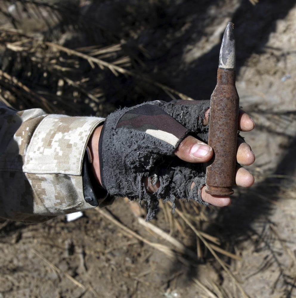 An engineer displays a bullet found near a weapons cache Canvas Art - Stocktrek Images (28 x 28)
