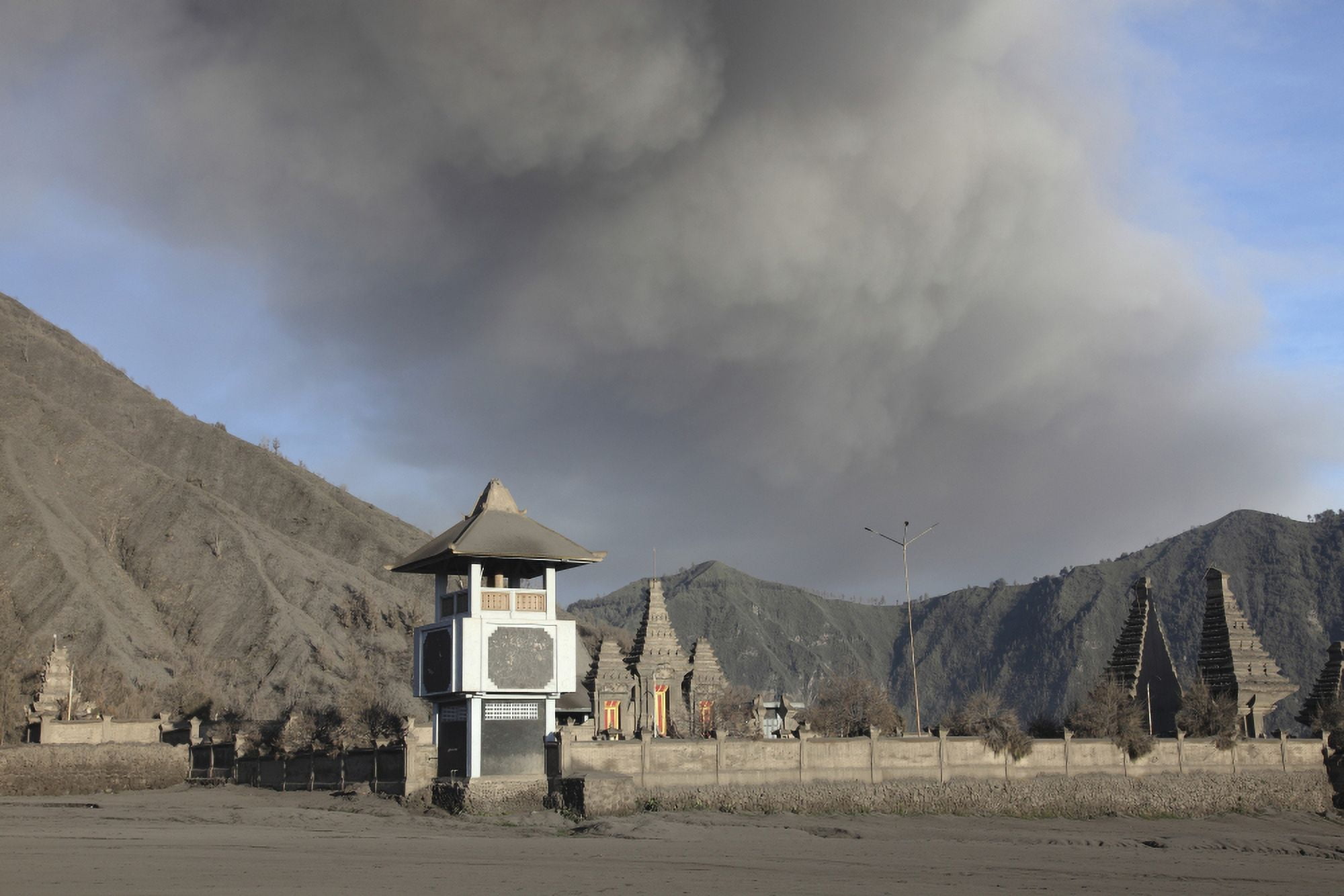 Ash cloud passing over temple at foot of Mount Bromo Volcano Tengger Caldera Java Indonesia Canvas Art - Richard RoscoeStocktrek Images (18 x 12)