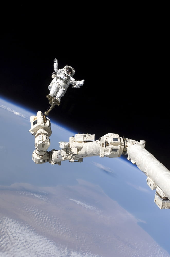 Astronaut anchored to a foot restraint on the International Space Stations Canadarm2 Canvas Art - Stocktrek Images (23 x 34)