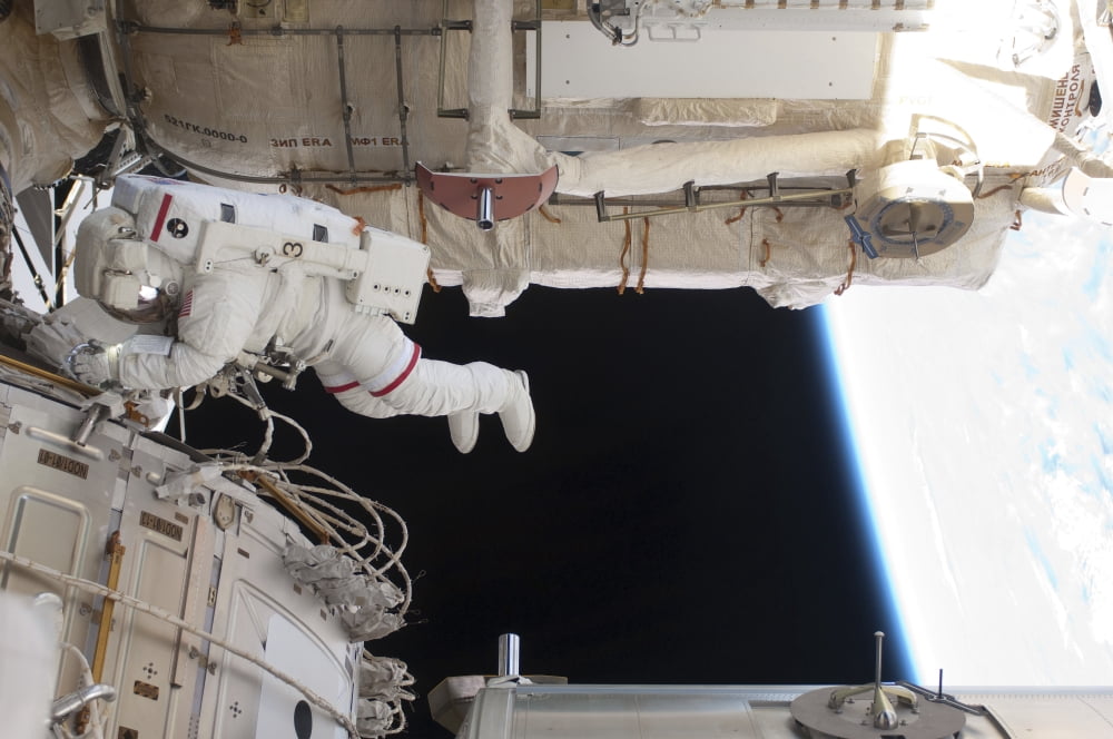 Astronaut conducts a spacewalk on the International Space Station Canvas Art - Stocktrek Images (34 x 23)