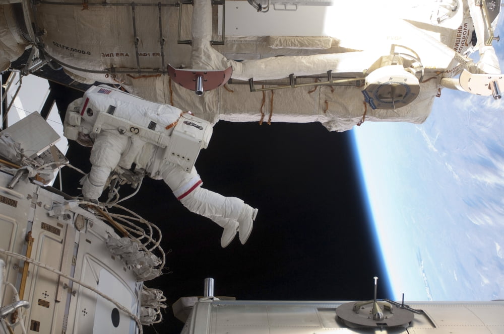 Astronaut conducts a spacewalk on the International Space Station Canvas Art - Stocktrek Images (34 x 23)