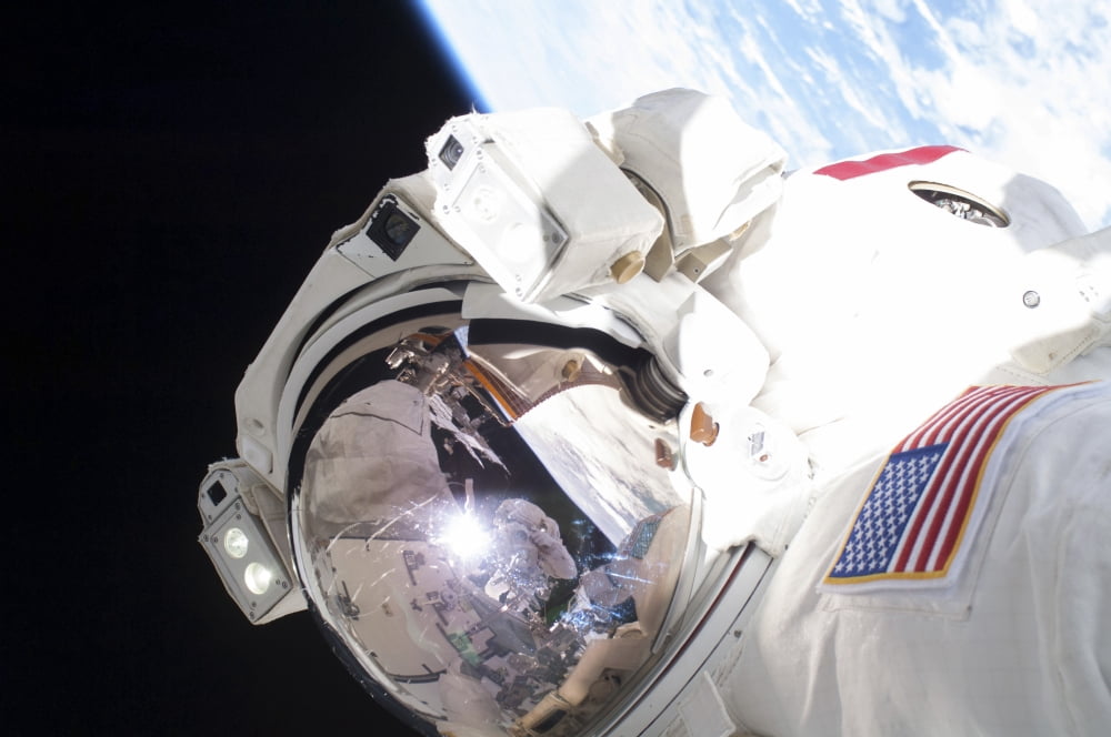 Astronaut during a spacewalk with Earth in background Canvas Art - Stocktrek Images (34 x 23)