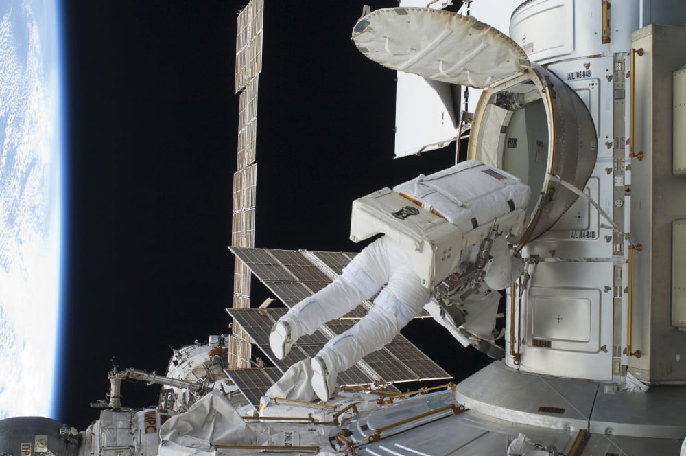 Astronaut egresses the Quest airlock on the International Space Station Canvas Art - Stocktrek Images (34 x 23)