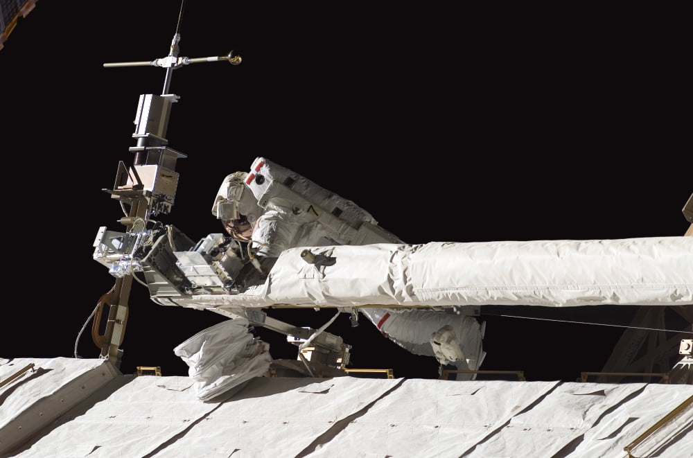 Astronaut helps to tie down the Orbiter Boom Sensor System on the International Space Stations S1 truss Canvas Art - Stocktrek Images (34 x 23)