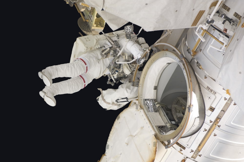 Astronaut ingresses the airlock hatch on the International Space Station Canvas Art - Stocktrek Images (34 x 23)