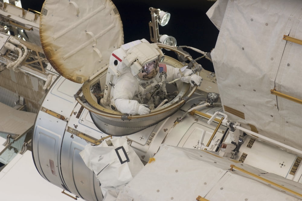 Astronaut ingresses the airlock hatch on the International Space Station Canvas Art - Stocktrek Images (34 x 23)