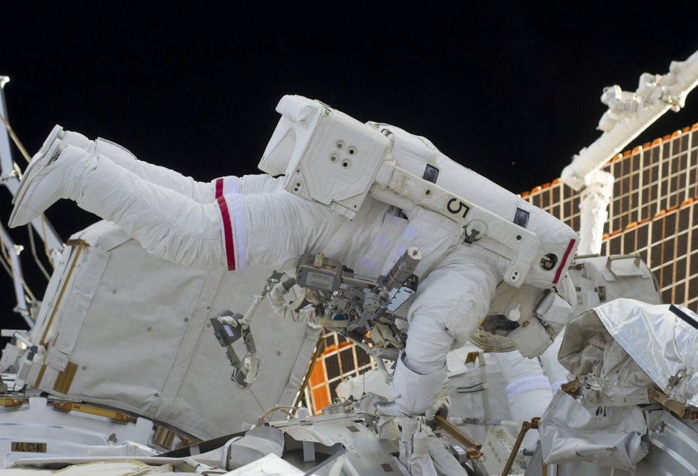 Astronaut participates in extravehicular activity on the International Space Station Canvas Art - Stocktrek Images (34 x 24)