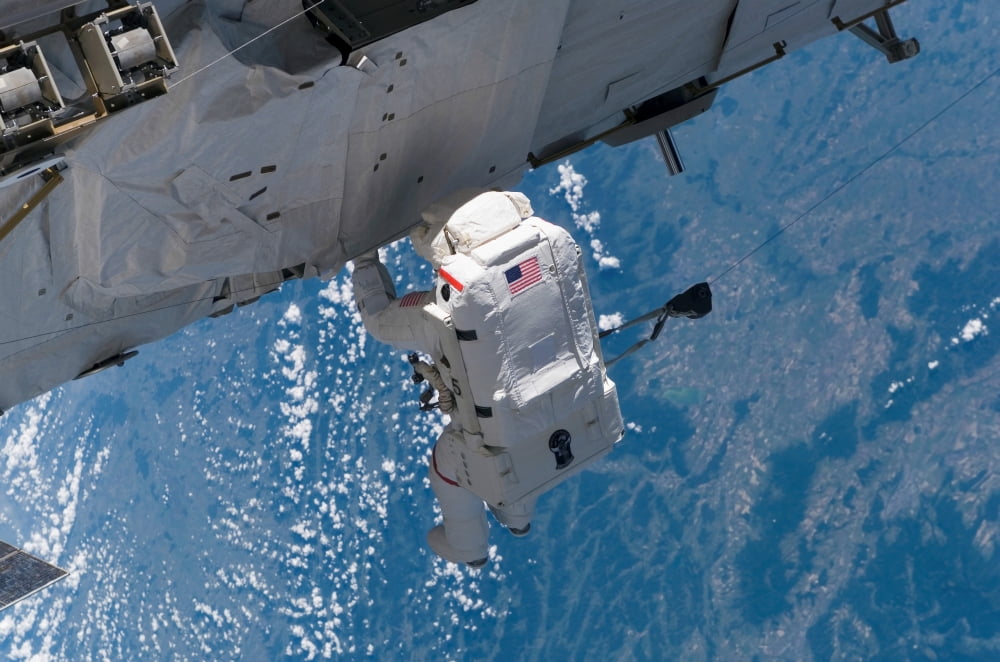 Astronaut traverses along the station hardware on the International Space Station Canvas Art - Stocktrek Images (34 x 23)
