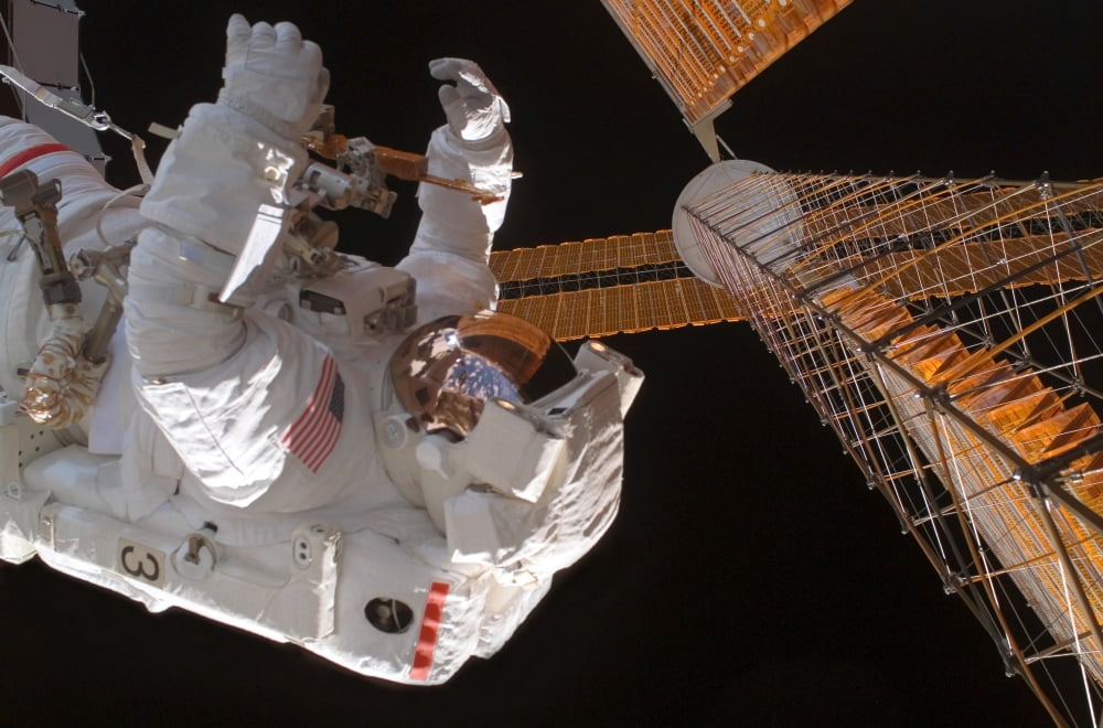 Astronaut works with the port overhead solar array wing on the International Space Station Canvas Art - Stocktrek Images (34 x 23)