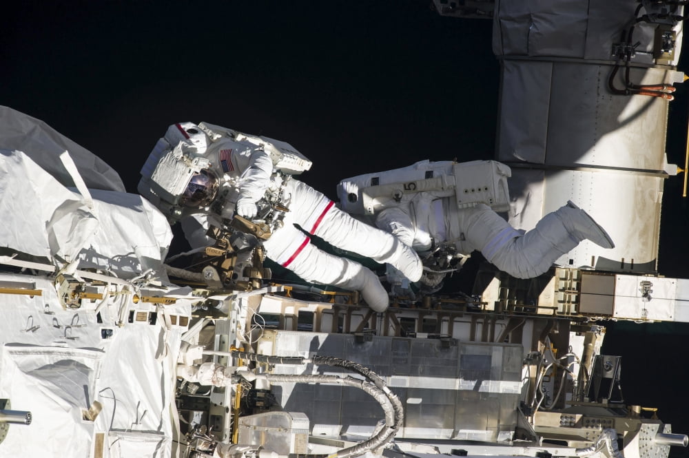 Astronauts inspect and replace a pump controller box on the International Space Station Canvas Art - Stocktrek Images (34 x 23)