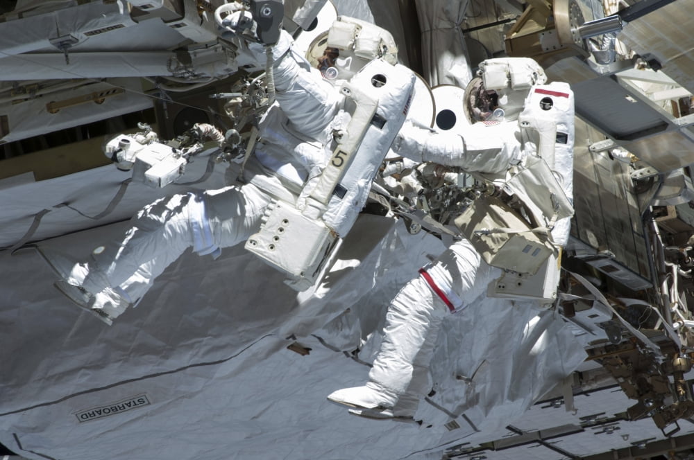 Astronauts participate in a spacewalk on the International Space Station Canvas Art - Stocktrek Images (35 x 23)