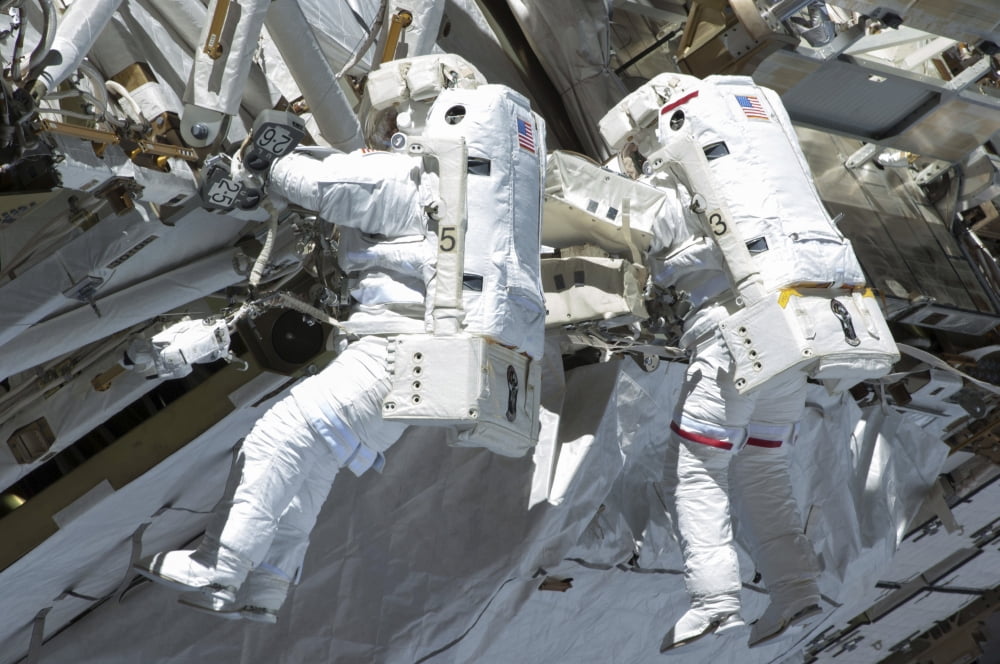 Astronauts participate in a spacewalk on the International Space Station Canvas Art - Stocktrek Images (35 x 23)