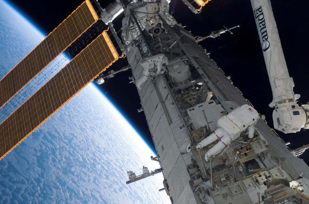 Astronauts participate in extravehicular activity Canvas Art - Stocktrek Images (34 x 23)
