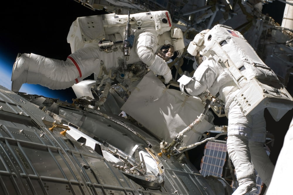 Astronauts participate in extravehicular activity Canvas Art - Stocktrek Images (34 x 23)
