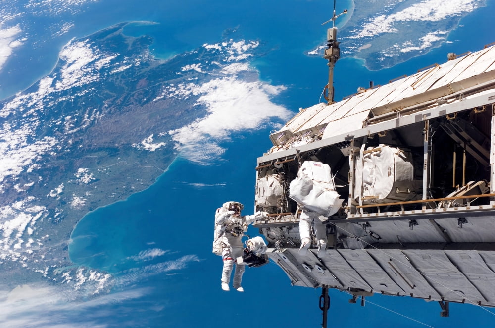 Astronauts participate in extravehicular activity Canvas Art - Stocktrek Images (34 x 23)