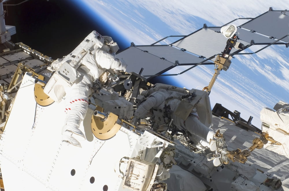 Astronauts participate in extravehicular activity Canvas Art - Stocktrek Images (34 x 23)