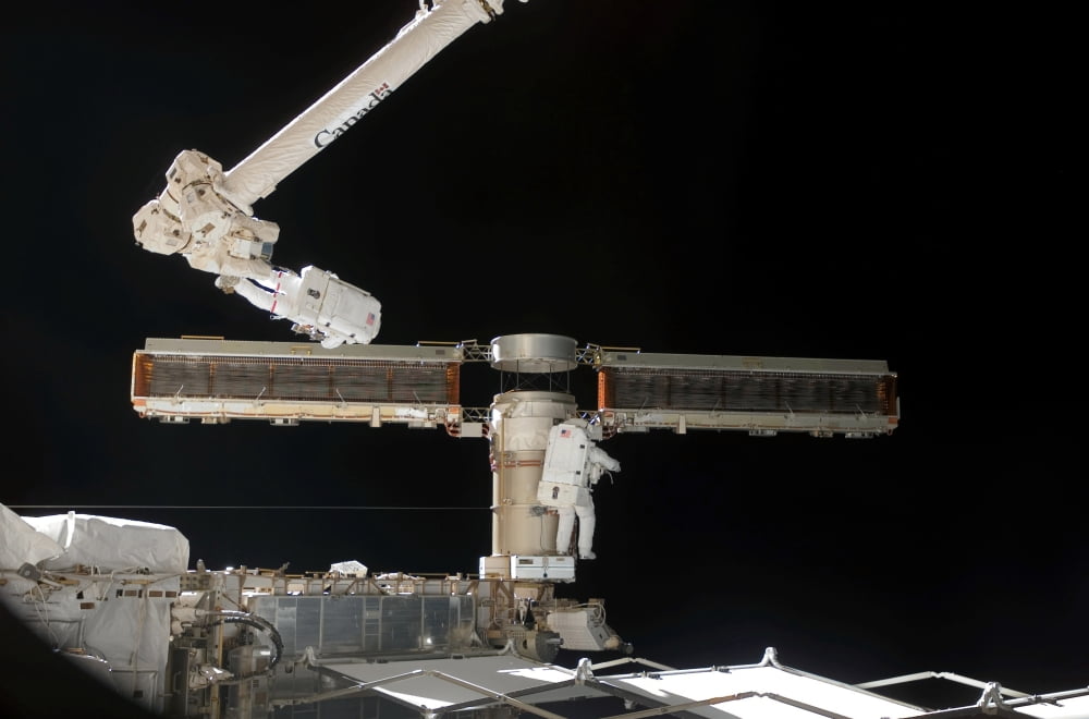 Astronauts participate in extravehicular activity Canvas Art - Stocktrek Images (34 x 23)