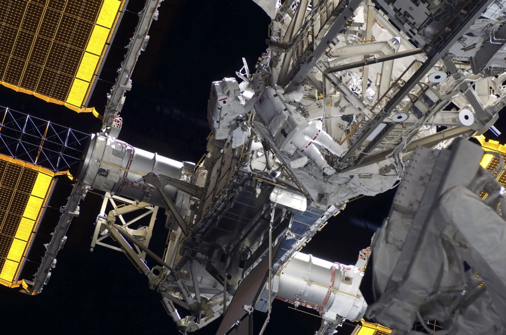 Astronauts participate in extravehicular activity Canvas Art - Stocktrek Images (35 x 23)